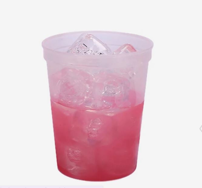 A photo of a plastic cup filled with ice, turning red.