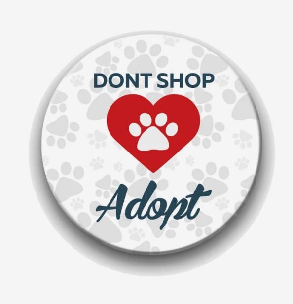 An ad saying Don't Shop, Adopt with a pawprint in a heart, printed on a circular magnet.