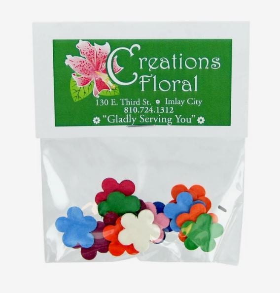 A photo showing colorful heart-shaped seed paper confetti in a clear plastic bag with Creations Floral printed on the label.
