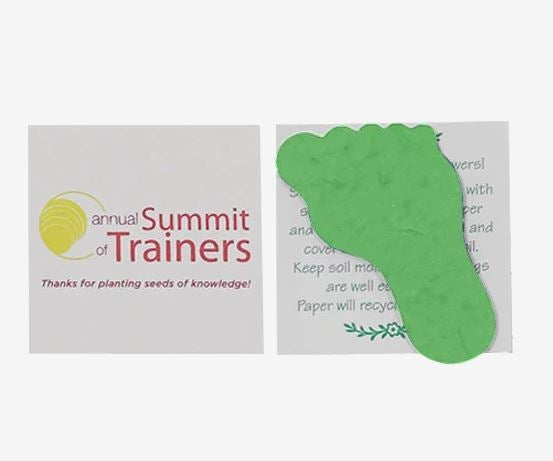 A photo showing green seed paper shaped like a footprint, with Summit Trainers printed on the front of the packet.