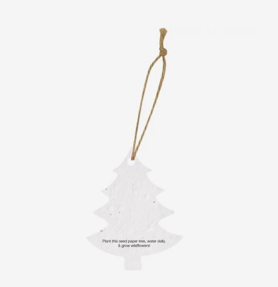 A photo showing a Christmas tree-shaped seed paper ornament with a brown string at the top and planting instructions printed at the bottom.