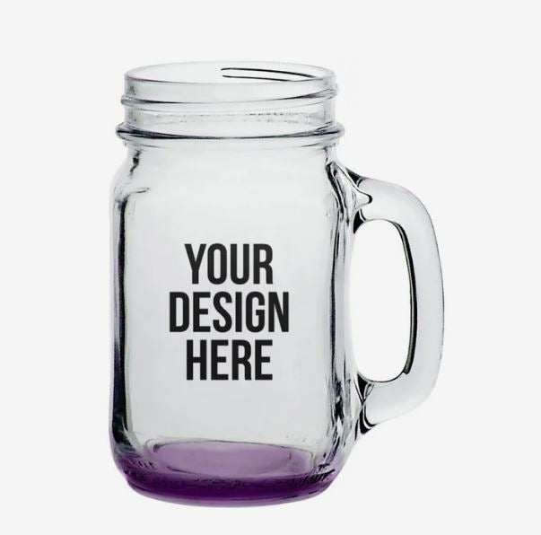 A photo of a mason glass with a handle and purple bottom, and with YOUR DESIGN HERE printed on it.