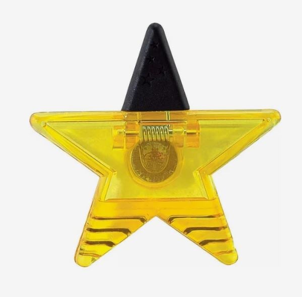 A photo of a yellow star-shaped plastic clip.