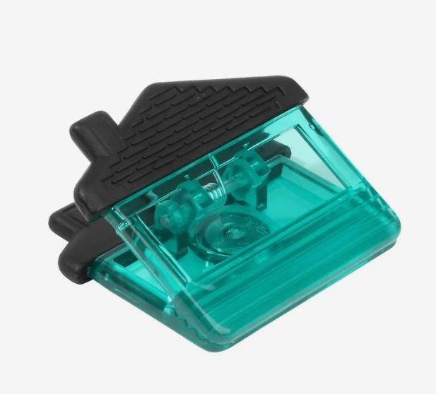 A photo of a house-shaped transparent turquoise plastic clip.
