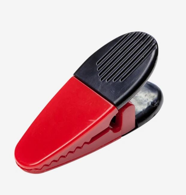 A photo of a black and red plastic clip.