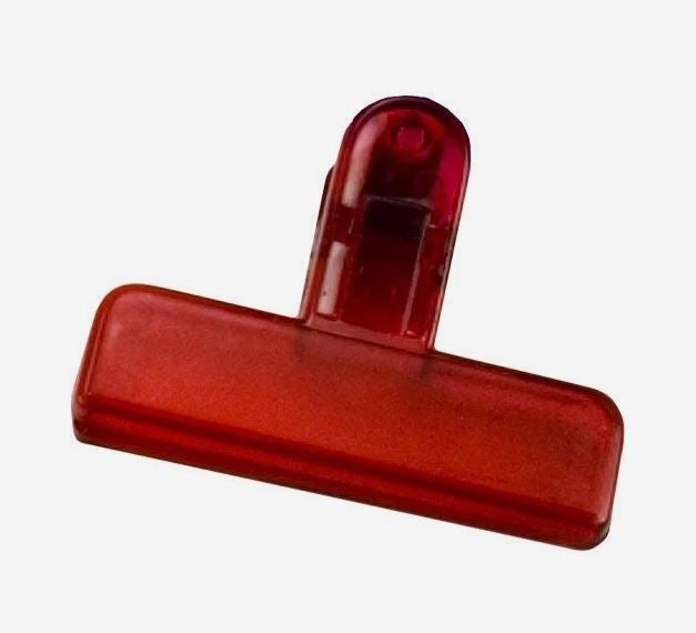 A photo of a red plastic clip.
