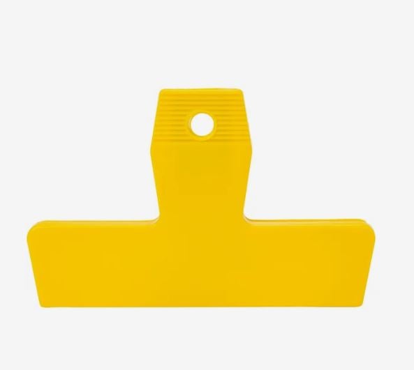 A photo of a yellow plastic clip.