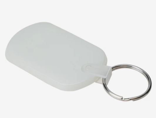 A photo of an oblong glow in the dark plastic key tag attached to a split ring.