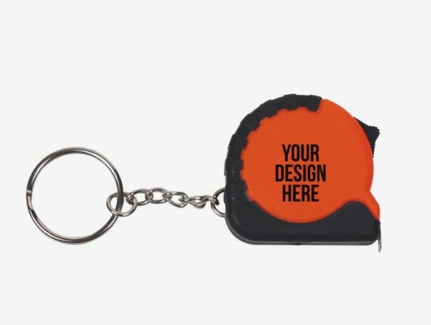 A photo of an orange tape measure keychain with YOUR DESIGN HERE printed on it in black.