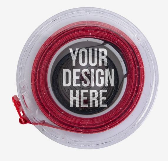 A photo of a clear plastic tape measure with a red tape, and YOUR DESIGN HERE printed on it in white.