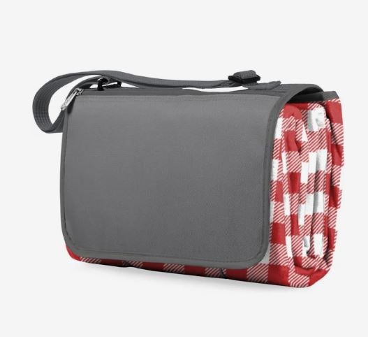 A photo of a red and white folded picnic blanket with a grey flap and handle.