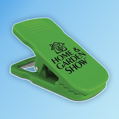 A photo of a green peg-shaped clip with HOME & GARDEN SHOW printed on it in black.