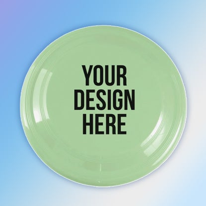 A photo of a pale green glow-in-the-dark flyer printed with YOUR DESIGN HERE on the top, against a blue background.