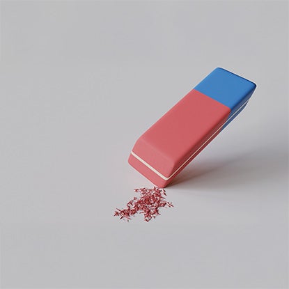 A photo showing a classic pink and blue parallelogram eraser on a white background next to a small pile of pink shavings.