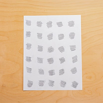 A photo showing a piece of white printer paper with 30 pencil scribbles in a grid.