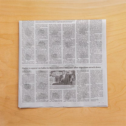 A photo showing a newspaper with 30 pencil scribbles in a grid.
