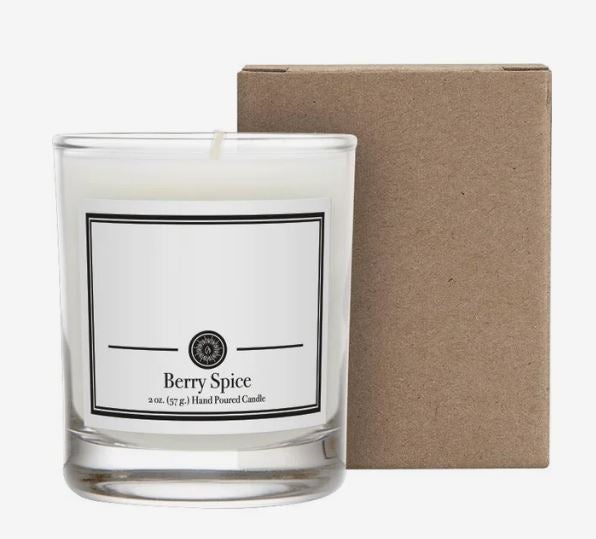 White Berry Spice scented candle in a clear glass jar with a printed label, displayed beside a plain brown cardboard gift box.