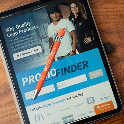 A photo showing a tablet with an orange stylus pen resting on the top.