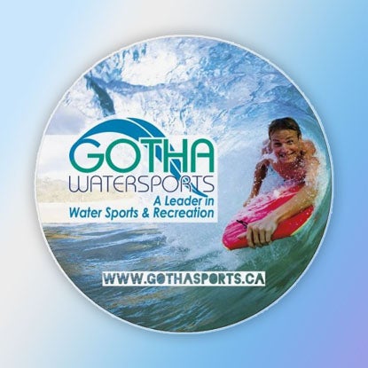 A photo of a circular magnet printed with an ad for Gotha Watersports.