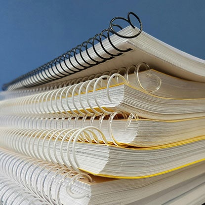 A close-up photo showing a stack of spiral notebooks.